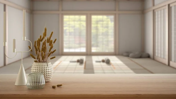 Wooden table, desk or shelf close up with ceramic and glass vases with dry plants, straws over blurred view of meditation space, eastern yoga class, modern interior design concept