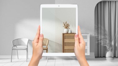 Ellerinde tahta oturma odasını gösteren tablet, tamamen boş proje geçmişi, artırılmış gerçeklik konsepti, mobilya ve iç tasarım ürünlerini taklit etmek için uygulama