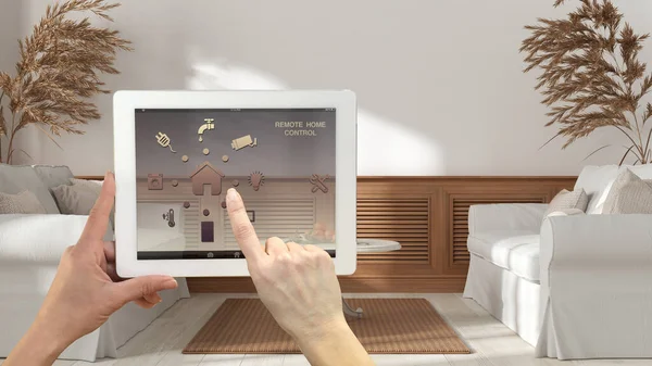 Smart remote home control system on a digital tablet. Device with app icons. Modern wooden living room with sofa and wood wall panel, in the background, architecture interior design