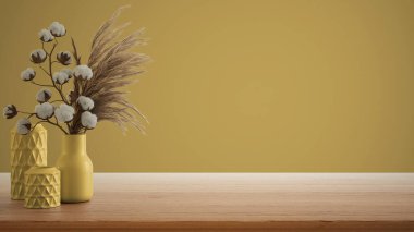 İç dizayn konsepti, ahşap masa, masa ya da rafı kapat. Kuru bitkilerle seramik vazolar ve pamuk çiçekleri. Kopyalama alanı olan sarı arkaplan, şablon model fikri