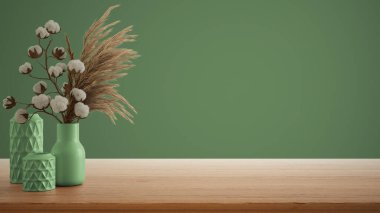 İç dizayn konsepti, ahşap masa, masa ya da rafı kapat. Kuru bitkilerle seramik vazolar ve pamuk çiçekleri. Kopyalama alanı olan yeşil arkaplan, şablon oluşturma fikri