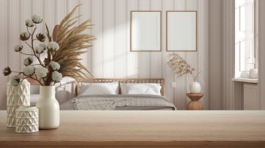 Ahşap masa, masa ya da raf, seramik vazolarla kaplanmış, ülke yatak odasının üzerinde pamuk çiçekler, duvar kağıdı, boho tarzı iç tasarım konsepti.