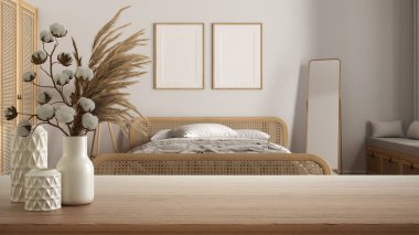 Ahşap masa, masa ya da raf seramik vazolar ve pamuklu vazolar ile bohem rattan yatak odasının üzerinde çerçeve modeli, boho tarzı iç tasarım konsepti.