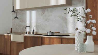 Japandi trendy wooden kitchen and dining room in white and beige tones. Close up on table with cotton flowers, wallpaper, cabinets and marble top. Minimalist interior design