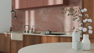 Japandi trendy wooden kitchen and dining room in white and orange tones. Close up on table with cotton flowers, wallpaper, cabinets and marble top. Minimalist interior design