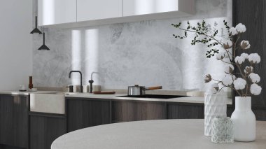 Japandi trendy wooden kitchen and dining room in white and dark tones. Close up on table with cotton flowers, wallpaper, cabinets and marble top. Minimalist interior design