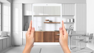 Hands holding tablet showing japandi kitchen, total blank project background, augmented reality concept, application to simulate furniture and interior design products