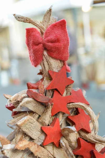Arc rouge et étoiles sur un sapin de Noël en bois — Photo