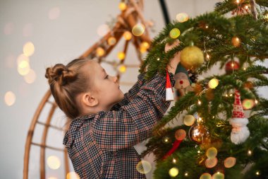 Bir kız bir Noel ağacı süsle