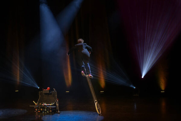 Juggler clown in the circus arena on a unicycle