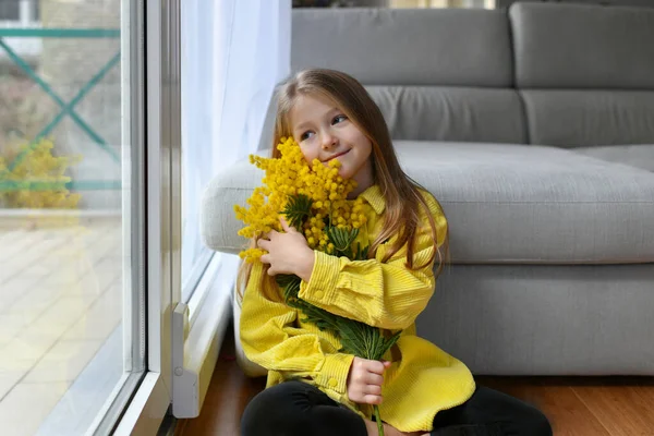 Mädchen hält Mimosen auf weißem Hintergrund — Stockfoto