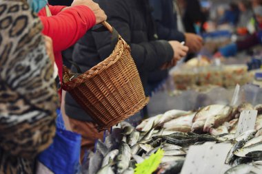Müşteri Ringa balığıyla tezgahın yanında bir sepet