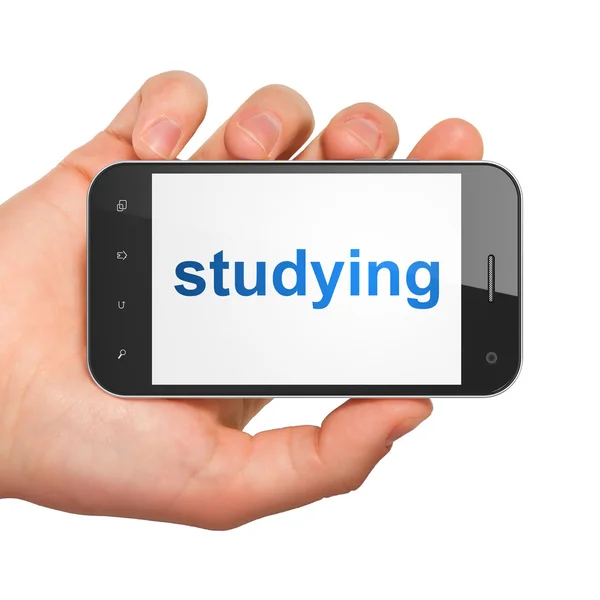 Hand met smartphone met woord studeren op display. generieke m — Stockfoto
