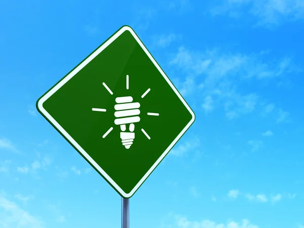 Concept d'entreprise : Lampe à économie d'énergie sur fond de panneau de signalisation routière — Photo