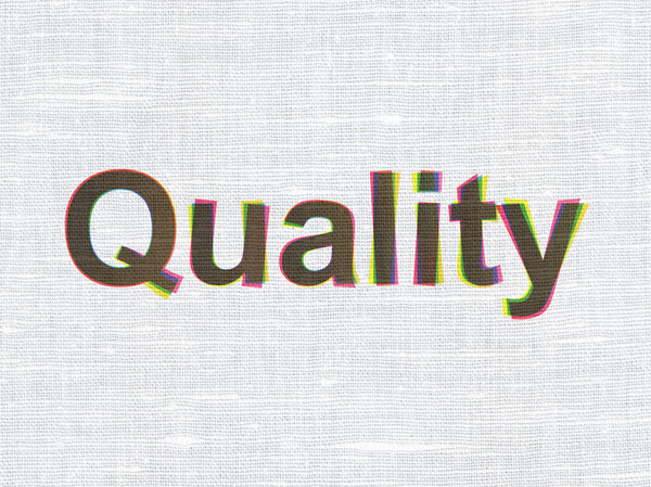 Концепция рекламы: Качество на фоне текстуры ткани
