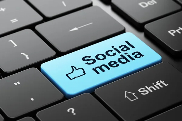 Палец вверх и социальные медиа на фоне клавиатуры компьютера — стоковое фото