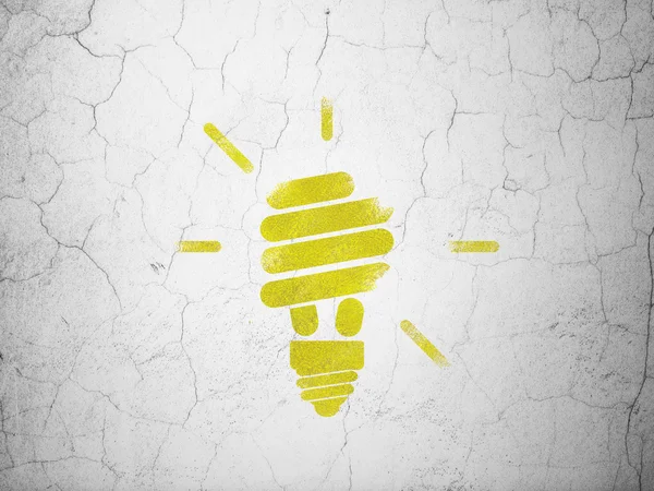 Bedrijfsconcept: energiebesparende lamp op muur achtergrond — Stockfoto