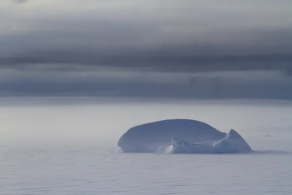 Pequeño iceberg que congeló las aguas antárticas en un día nublado y nublado — Foto de Stock