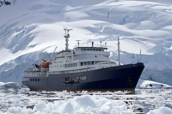 Velké modré turistické lodí ve vodách Antarktidy proti o pozadí Stock Snímky