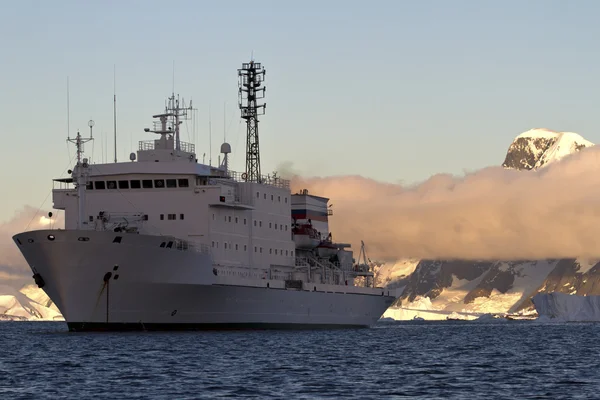 Mount bir arka plan üzerinde günbatımında bağlantılı yolcu gemisi — Stok fotoğraf