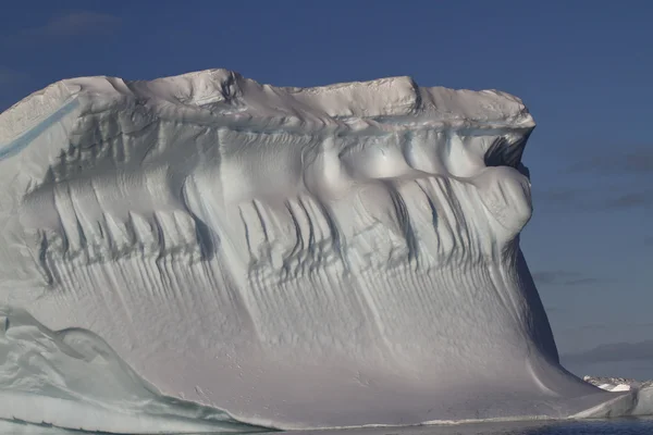 Iceberg avec un mur diffus contre le ciel bleu en Antarctique — Photo