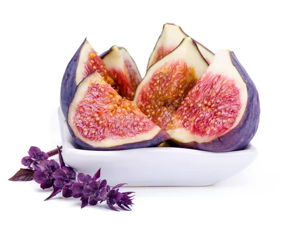 Some juicy, ripe slices of fig and basil flower — Stock Photo, Image