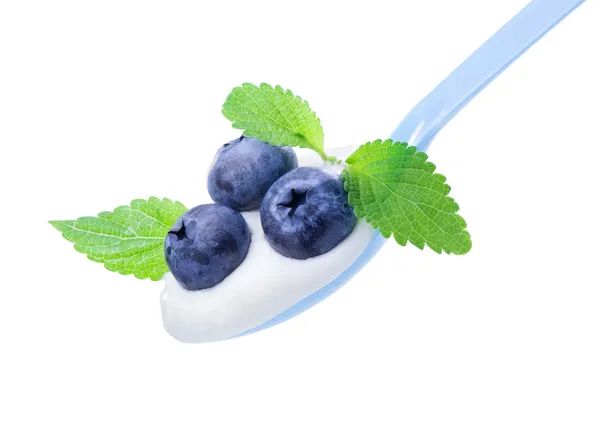 Blueberry on white yogurt and leaves of mint, in blue spoon — Stock Photo, Image