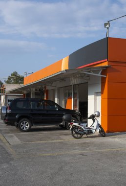 Yunanistan 'da bir araba hizmet binasının önünde arabalar park halinde.