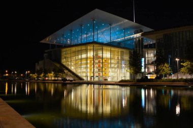 Stavros Niarchos Cultural Center in Athens, Greece at night with reflection in the water