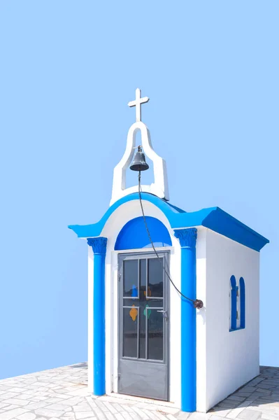 Traditional Greek small church in blue and white style on a blue background in Greece