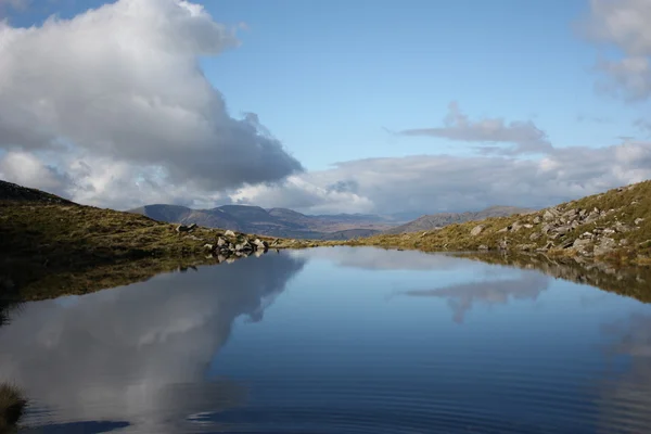 Un lago de montaña con vistas al campo galés — Foto de Stock
