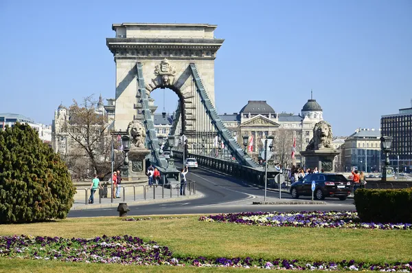 BUDAPEST - CIRCA MAR 2012: Turistas visitam Chain Bridge no dia 21 M Fotos De Bancos De Imagens