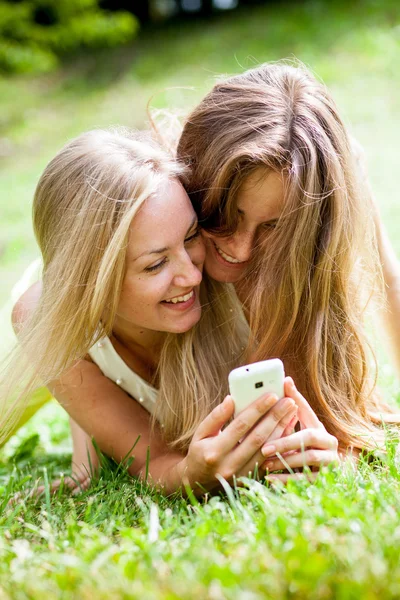 Mädchen im Park mit Mobiltelefonen — Stockfoto