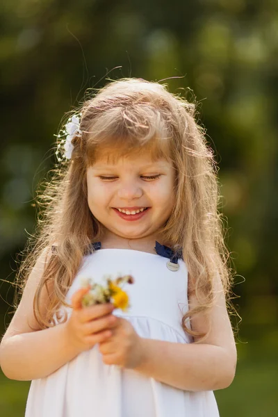 Девушка с подсолнухом на летнем поле — стоковое фото