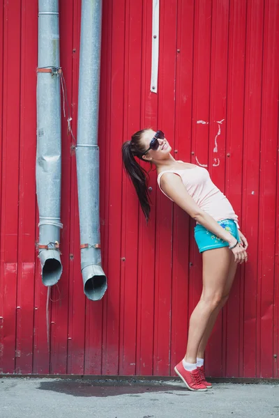 Menina de pé nas paredes vermelhas — Fotografia de Stock