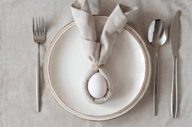 Paskalyanız kutlu olsun. Paskalya sofrasında keten peçete ve yumurtadan yapılmış Paskalya tavşanı. Zarif Paskalya brunch sofrası. Üst görünüm
