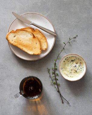Sandwiches with herbs butter on a gray background. Herb butter in a bowl on concrete background. Healthy homemade herb butter and bread 