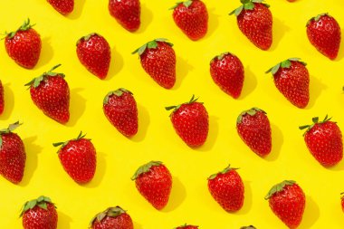 Fresh red strawberry isolated on yellow background, top view. Minimalistic strawberry pattern. Flat lay, copy space