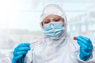 Tıbbi sağlık hizmeti NHS teknisyenleri, COVID-19 örnek toplama kiti, beyaz PPE koruyucu giysi maskeli eldivenler, OP NP hasta numune örneği almak için test tüpü, PCR DNA test süreci