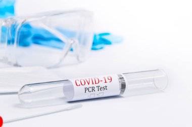 Kit, Covid-19, Coronavirus semptomlarını PPE ve PCR testleriyle test etti. Beyaz arka plan, gözlük, maske ve eldivenler virüse karşı korunmak için.