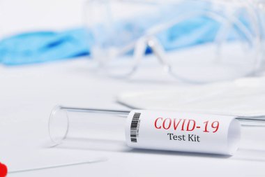 Kit, Covid-19, Coronavirus semptomlarını PPE ve PCR testleriyle test etti. Beyaz arka plan, gözlük, maske ve eldivenler virüse karşı korunmak için.