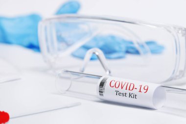 Kit, Covid-19, Coronavirus semptomlarını PPE ve PCR testleriyle test etti. Beyaz arka plan, gözlük, maske ve eldivenler virüse karşı korunmak için.