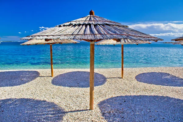 卵石海滩和绿松石海伞 — 图库照片