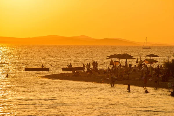 Mensen op het strand silhouetten — Stockfoto