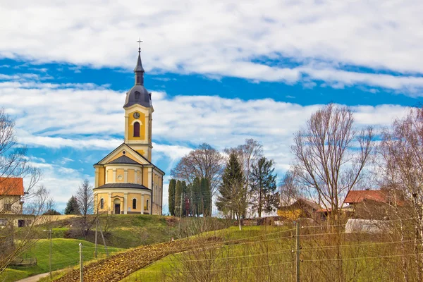 Chiesa cattolica sulla collina idilliaca del villaggio — Foto Stock