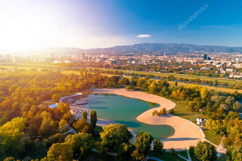 Bundek lake and city of Zagreb aerial autumn sun haze view, green zone of capital of Croatia