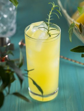 Armut Colins Kokteyli. İçi armut püresi kokteyli dolu viski bardağı ya da turkuaz masa yüzeyindeki malzemeler ve bar aletleriyle çevrili moktakolar içilmeye hazır..