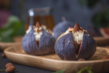 Maskaralık peynirli taze çiğ incir, badem ve bal ya da ahşap tepside akçaağaç şurubu. Yemek için hazır..