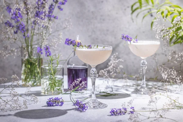 라벤더 Lavender Cocktail 이라는 유리잔은 재료와 라벤더 그리고 테이블 표면에 스톡 사진