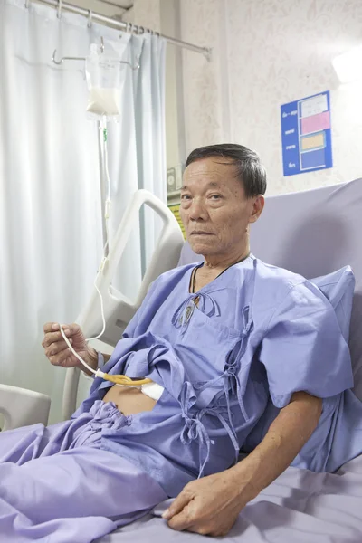 Old man patient feeding liquid food on hospital bed — Stock Photo, Image
